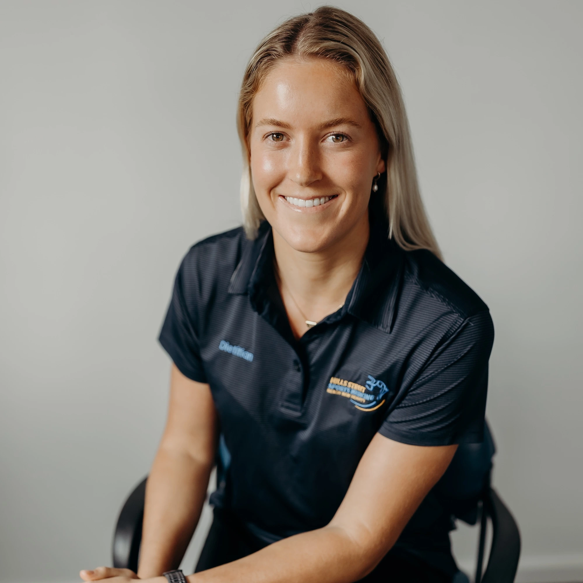 Paris, Gosford-based Accredited Practising Dietitian (APD), smiling in clinic uniform